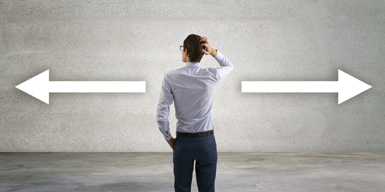 Pessoa indecisa segurando placas com diferentes escolhas